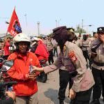 Aksi Humanis Polres Pelabuhan Tanjung Priok Bagikan Minum dan Roti Saat Buruh Rayakan May Day