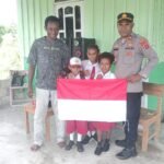 Sambut HUT Ke-81 Kemerdekaan RI, Kapolsek Senggi Bagikan Bendera Merah Putih kepada Warga